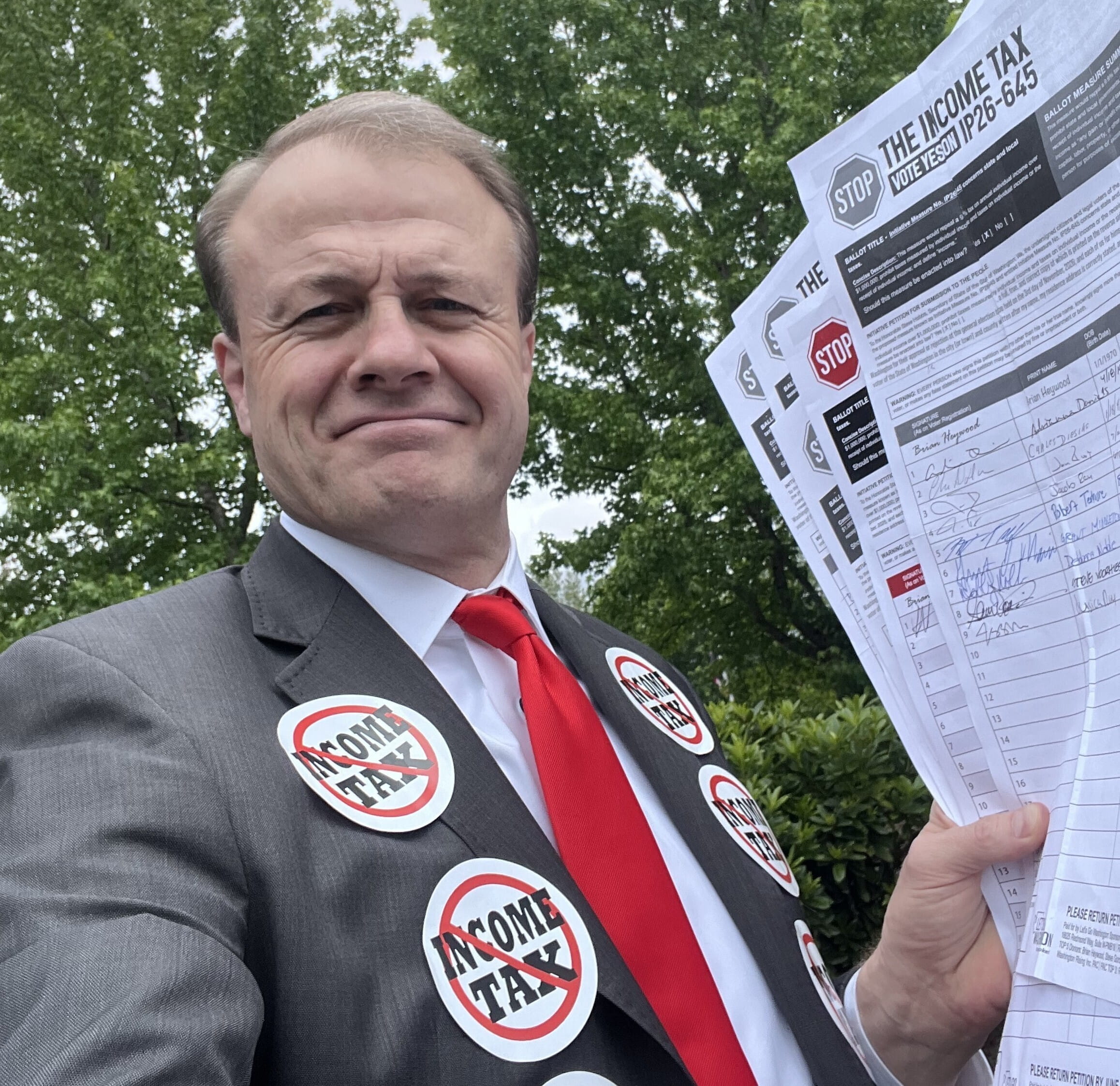 Picture of Tim Eyman holding signature petitions at the Secretary of State's office